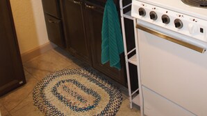Une cuisine équipée d’un évier, d’une cuisinière et de placards.