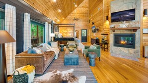 A cozy cabin-style interior with a fireplace, wooden walls, and a comfortable seating area.
