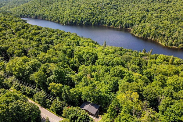 Aerial view of the peaceful lake and surrounding forest landscape.