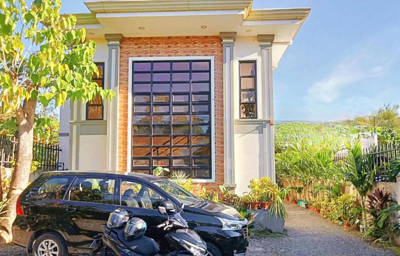 A house with a garage, a driveway, and a motorcycle parked in front.