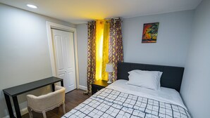 A hotel room with a bed, a desk, and a chair. - Charming 3-bedroom apartment with WiFi, AC in lovely Leominster (Leominster)