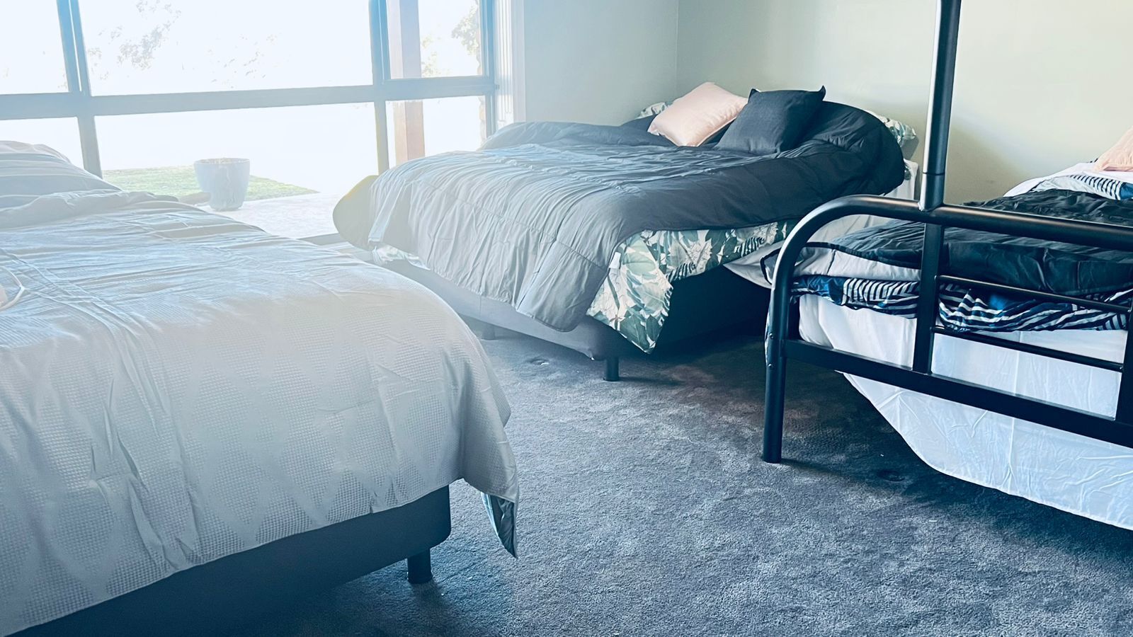 Een kamer met twee bedden, waarvan één met een baldakijn en de ander met een metalen frame.