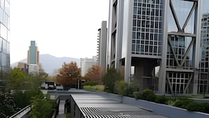 A modern building with a sloped roof and a pathway leading to a covered area.