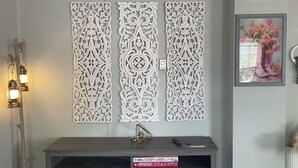 A bathroom with a vanity, a framed floral artwork, and decorative wall panels. - Peach Place (McGill)