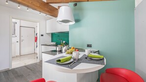 A modern kitchen with a teal accent wall, wooden beams, and a central island with seating.