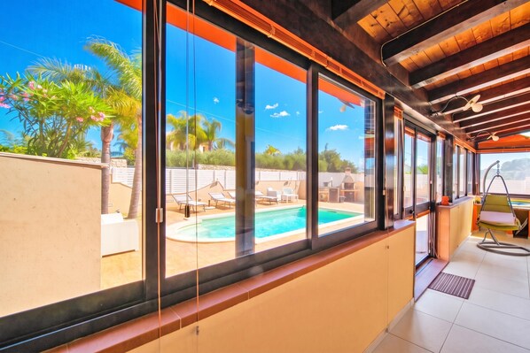 A modern room with large windows, a pool, and outdoor furniture. - Casa Plaja, Scicli, Italy (Scicli)
