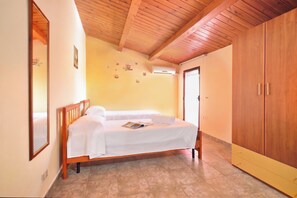 A bedroom with a wooden bed, a wardrobe, and a tiled floor. - Casa Plaja, Scicli, Italy (Scicli)