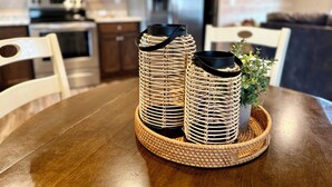 A dining table with woven candle holders and a small plant. - Squirrel's Nest (Fort Payne)