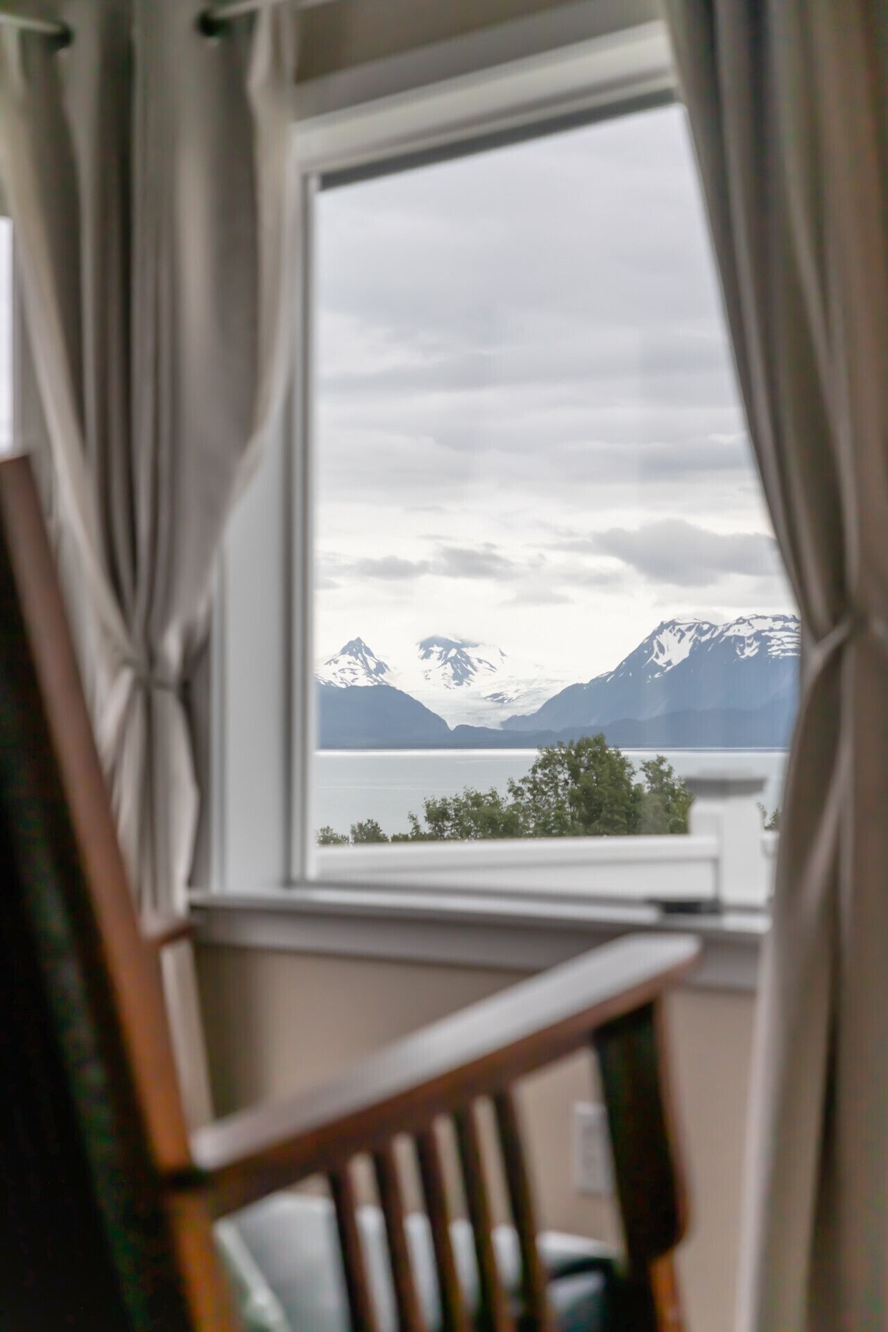 A room with a window overlooking a mountain landscape.