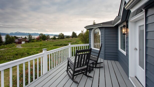 A wooden deck with a white railing, a rocking chair, and a bench. - Benchwarmer`s Bliss (Homer)