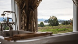 A bathroom with a view of a lake, mountains, and a field of flowers. - Benchwarmer`s Bliss (Homer)