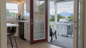 A kitchen with a sliding glass door leading to an outdoor grill area. - Benchwarmer`s Bliss (Homer)