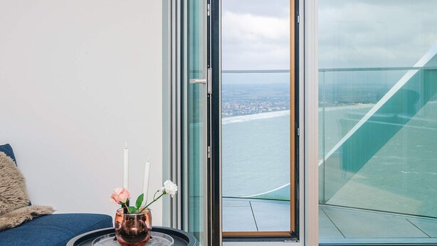 A modern room with a glass balcony overlooking a coastal cityscape. - 5 Star Holiday Home in Aarhus C (Aarhus)