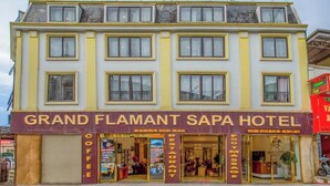 A multi-story building with a sign for the Grand Flamant Sapa Hotel. - Flamant Boutique Hotel (Sa Pa)