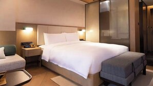 A modern hotel room with a large bed, bedside tables, a desk, and a seating area. - Yueyin Chongqing Courtyard (Chongqing)