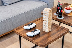 Una mesa de centro de madera con dos controles de videojuegos blancos y una pila de bloques de madera.