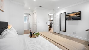 Ein modernes Schlafzimmer mit Bett, Nachttisch und einem großen Spiegel.
