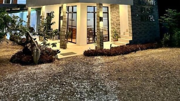 A modern two-story hotel with a balcony on the upper floor, large windows, and a well-lit entrance. - Harbour Bliss Hotel (Coron)