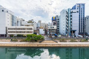 A waterfront urban area with modern buildings, a clear sky, and a calm water body.