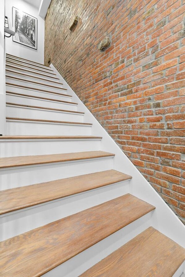 A staircase with wooden steps and a brick wall.