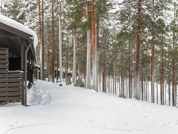 A snow-covered wooden cabin with a snow-covered roof and a snow-covered ground.