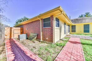 A single-story house with a brick exterior and a yellow front.