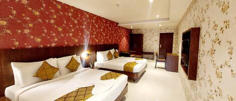 A hotel room with two beds, a desk, and a wardrobe.