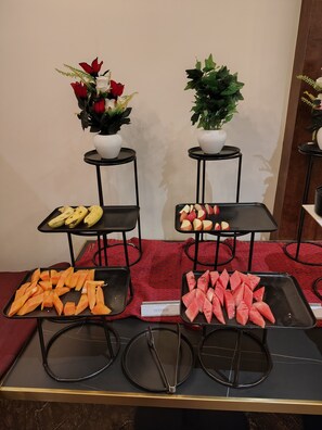 Ein Buffet mit verschiedenen Früchten und einer kleinen Topfpflanze.