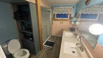 A compact bathroom with a toilet, a sink, and a mirror.
