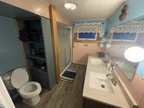 Une petite salle de bain comprenant des toilettes, un lavabo et un miroir.