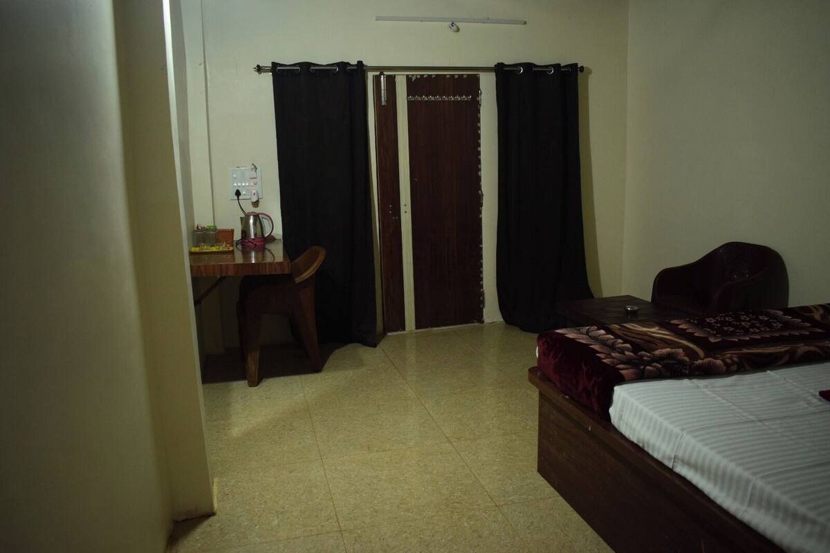 Quarto com cama, escrivaninha, cadeira e guarda-roupa.
