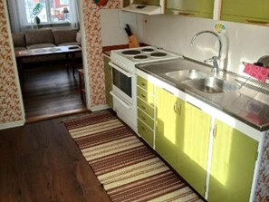A compact kitchen with a sink, stove, and cabinets.