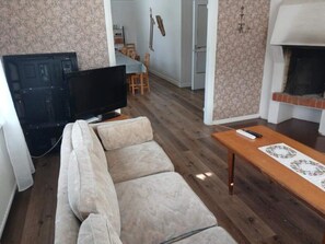 A living room with a sofa, a television, a fireplace, and a dining area in the background. - 12 Person Holiday Home in Lidsjoberg (Lidsjöberg)