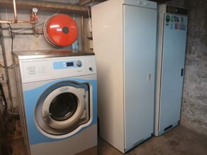 A laundry room with a front-loading washing machine and a refrigerator.