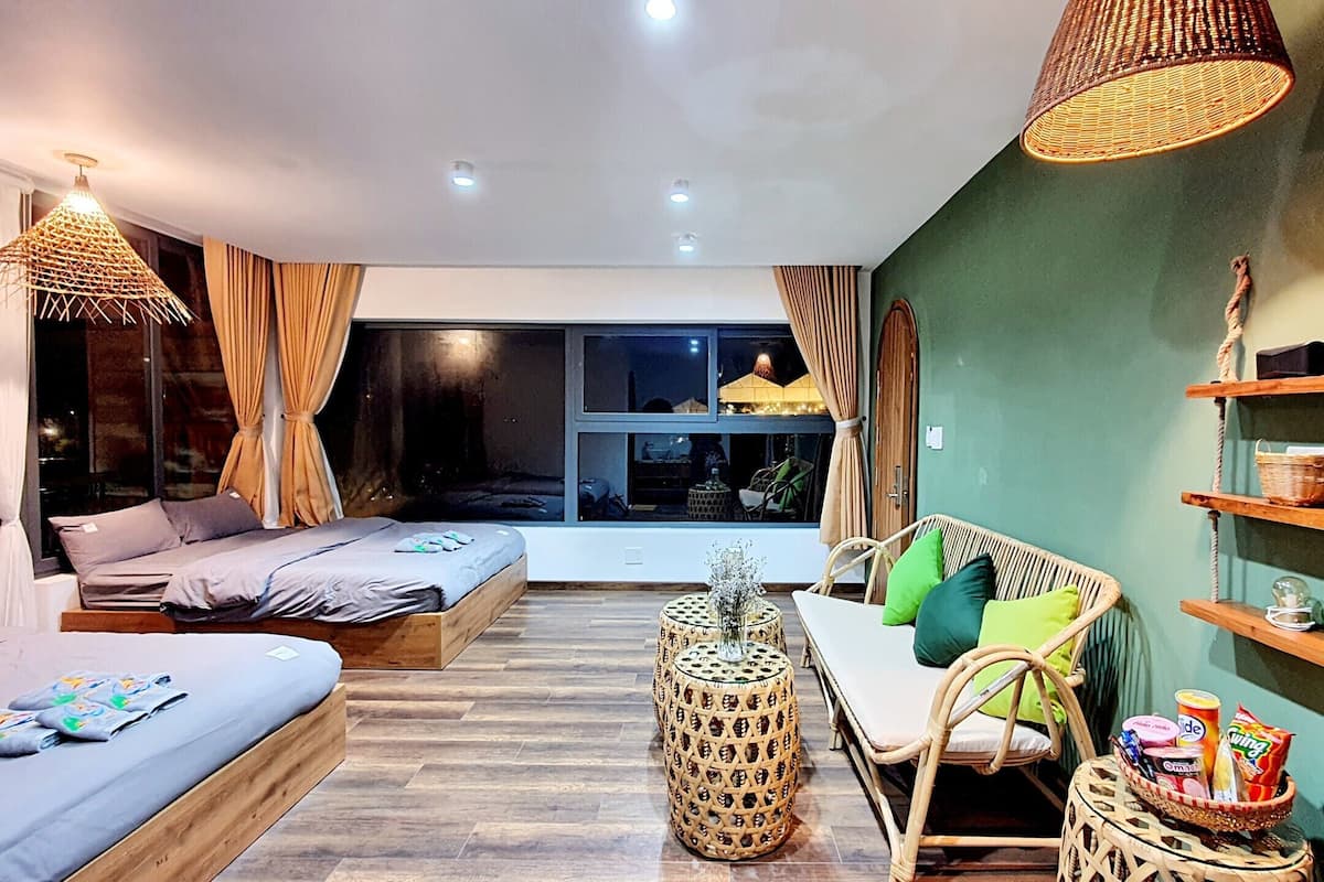 A modern bedroom with a bed, a chair, a round table, and a window with curtains.