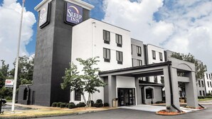 A Sleep Inn hotel with a modern facade, a flagpole, and a well-maintained entrance area. - Travelodge by Wyndham Flowood (Flowood)