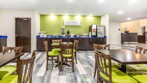A hotel room with a dining area, a kitchenette, and a bed. - Travelodge by Wyndham Flowood (Flowood)