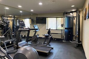Ein Fitnessstudio mit Laufbändern, Crosstrainern und Gewichten.