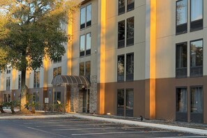 A multi-story hotel with a parking lot in front. - Wingate by Wyndham Jacksonville FL (Jacksonville)