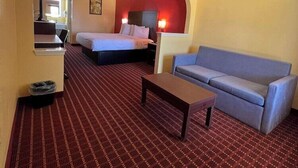 Ein Hotelzimmer mit einem Bett, einer Couch, einem Schreibtisch und einer Mülleimer.