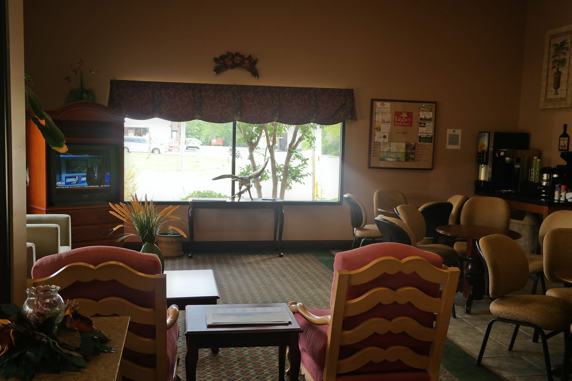A hotel lobby with a large window, seating area, and a television.