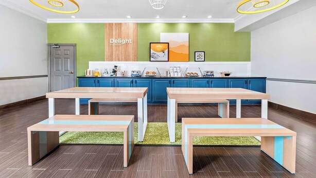 Una cocina moderna con armarios azules, una encimera de madera y una pared de acento verde.