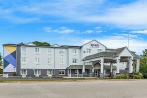 A multi-story hotel with a prominent 'Spark by Hilton' sign, a covered entrance, and a parking lot with marked disabled parking spaces. - Spark by Hilton St. Augustine I 95 (St. Augustine)