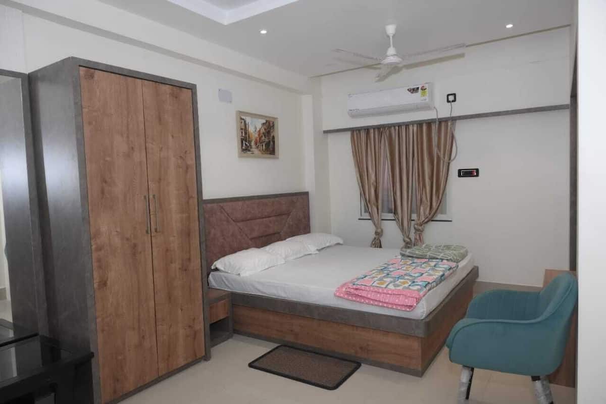 Une chambre à coucher comprenant un lit, une armoire, un bureau, une chaise et un appareil de climatisation.