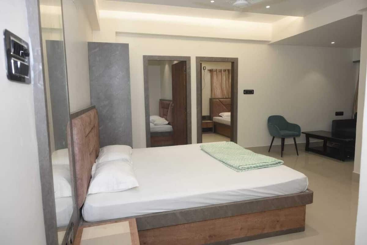 Une chambre d’hôtel moderne équipée d’un grand lit, d’un bureau, d’une chaise et d’un téléviseur.