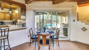 A kitchen with a dining area, wooden ceiling, and a view of a backyard with a pool. - From Balloon Fiesta Mornings to Fireside Nights (Albuquerque)