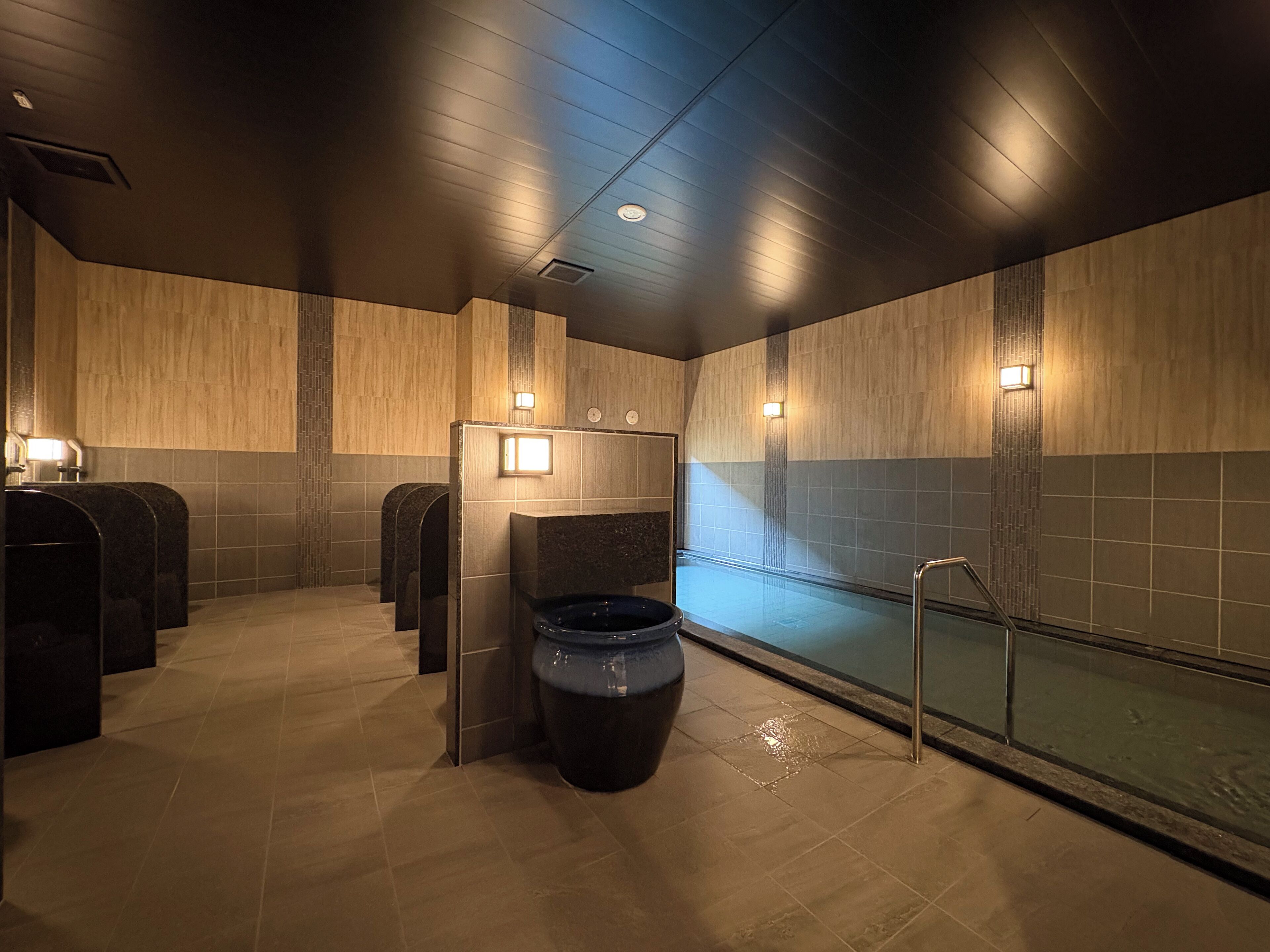 Un baño moderno con una bañera amplia, varios lavamanos e iluminación empotrada.