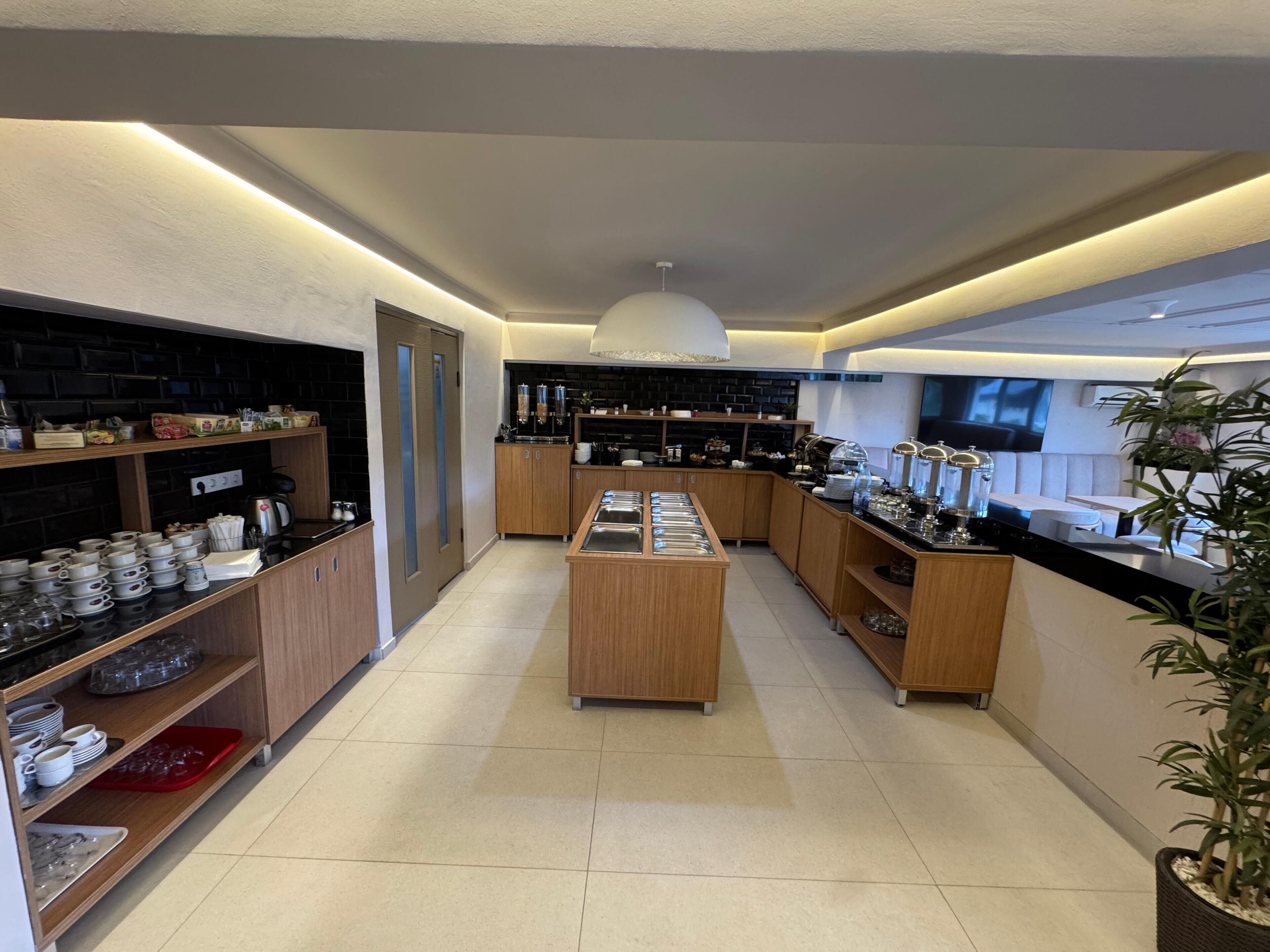 Una cocina moderna con armarios de madera, una isla central y encimera negra con cristalería.
