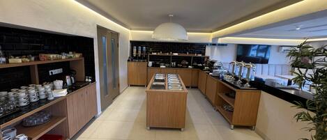 Una cocina moderna con armarios de madera, una isla central y encimera negra con cristalería.