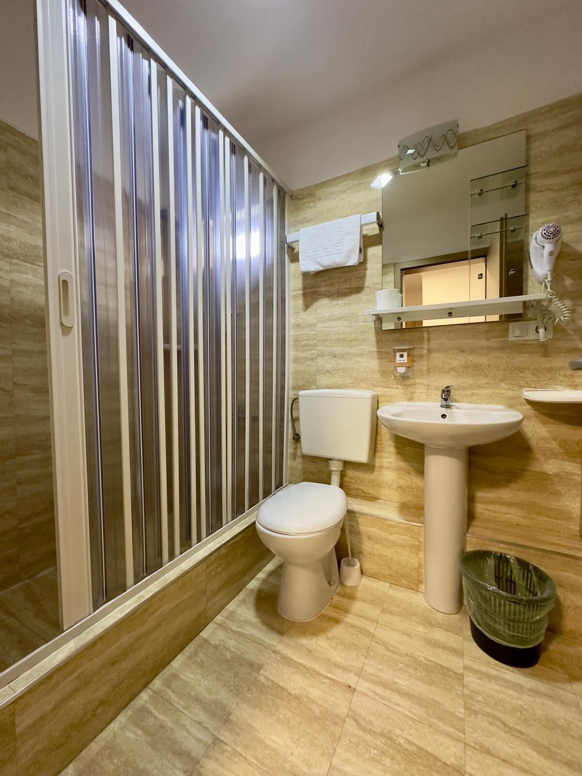 A modern bathroom with a toilet, sink, and shower.